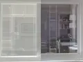 Fenêtre avec film phonique. La partie gauche est opaque, la droite laisse voir une cuisine moderne.