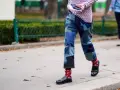 Uomo con jeans patchwork e mocassini neri, calzini rossi a fantasia.