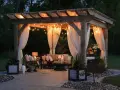 Mysig altan med pergola, draperade gardiner och stämningsfull belysning. Perfekt inspiration för din egen altanbelysning.
