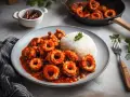 Calamares en salsa roja, servidos con arroz blanco y decorados con perejil. Un plato delicioso y apetitoso.