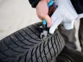 Rękawiczka i kombinerki usuwają gwóźdź z przebitej opony.