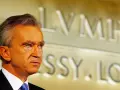 Bernard Arnault, proprietario Dior, guarda pensieroso. Sullo sfondo, il logo LVMH.