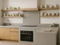 Progetto cucina in muratura moderna con pensili in legno, piano in resina e forno a incasso.