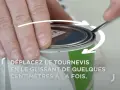 Main tenant un tournevis, on montre comment ouvrir un pot de peinture en faisant levier sur le couvercle.