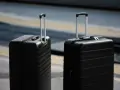 Dwa czarne walizki, idealne jako bagaż podręczny Ryanair, czekają na podróż.