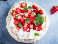 Pyszny deser Pavlova z truskawkami, idealny przepis na bezy z 3 białek. Lekka i chrupiąca beza z bitą śmietaną i owocami.