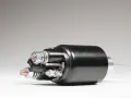 A black starter solenoid with copper and silver bolts, ready to power up an engine.