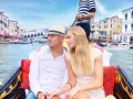 Coppia romantica su gondole a Venezia, con edifici storici sullo sfondo.