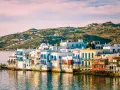 Charming waterfront houses with blue shutters, a classic view of places in Greece to visit.