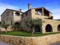 Magnifique maison en pierre calcaire avec des arches et un jardin verdoyant.