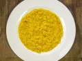 Un cremoso risotto alla milanese, con i suoi fili rossi di zafferano che promettono un sapore autentico.