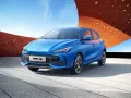 Niebieski samochód MG3 Hybrid+ na tle nowoczesnej architektury.
