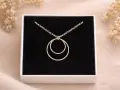Collana con due anelli intrecciati, simbolo di legame eterno e unione.