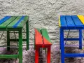 Muebles coloridos, como mesas y bancos, hechos con **objetos reciclados fáciles de hacer**.