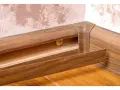Drewniane listwy przypodłogowe połączone w rogu, widoczny kanał na kable.