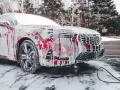 Czerwony samochód pokryty pianą, myty w zimnie. Czy można myc auto w mrozie? Tak, jeśli użyjesz odpowiednich środków.