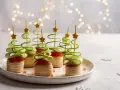 Aperitivos navideños en forma de árbol con pepino en espiral y estrellas doradas.