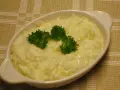En vit oval skål med krämig stuvad vitkål, toppad med färsk persilja. En klassisk svensk rätt som värmer själen.