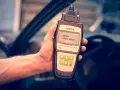 Hand holding an OBD2 scanner displaying code P0011, ready to diagnose car issues.
