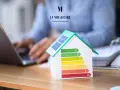 Modello di casa con pannelli solari e scala di efficienza energetica. La migliore immobiliare valuta la classe energetica casa.