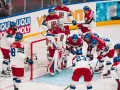 Czescy hokeiści w akcji podczas mistrzostw świata w hokeju 2024. Drużyna w białych strojach z czerwonymi i niebieskimi elementami walczy o zwycięstwo.