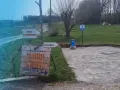 Miejsce na parking dla kamperów. Obok znak "Pole Namiotowe" i drogowskaz do smażalni pstrągów.