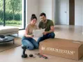 Para montażu schodów modułowych. Para przegląda instrukcję, obok leży karton z napisem "ATRIUM SYSTEM schody".