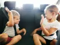 Dzieci w samochodzie kłócą się, podnosząc ręce. Może to być odpowiedź na pytanie, dlaczego rodzeństwo się nie lubi.