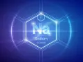 Symbol Na, liczba atomowa 11, nazwa Sodium (sód) i masa atomowa 22.9898 w centrum sześciokąta na tle technologicznym.
