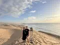 Dwie kobiety na wydmach nad oceanem, w tle inni turyści. Czy w Maroko jest bezpiecznie dla turystów? Tak, to piękny kraj.