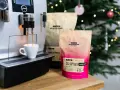 Espresso z ekspresu Jura, obok paczki kawy HAYB "Pink Espresso Barrel Aged". W tle choinka.