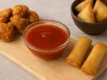 Nuggets croustillants, rouleaux de printemps dorés et samossas triangulaires attendant d'être trempés dans une sauce aigre douce appétissante.
