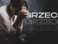 Kobieta z złożonymi dłońmi nad czołem, siedząca obok Biblii, symbolizuje ciężki grzech i pokutę.
