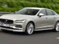 Eleganckie Volvo S90 w kolorze szampańskim pędzi po drodze. Choć piękny, warto pamiętać o potencjalnych wadach tego modelu.