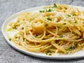 Pyszny makaron aglio e olio, idealny pomysł, z czym zrobić makaron na szybko. Posypany parmezanem i natką pietruszki.