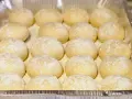 Piccolo pane fatto in casa, soffice e leggermente infarinato, pronto per essere infornato.