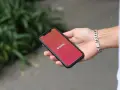 Dłoń trzyma smartfon z otwartą aplikacją Tinder. Zastanawiasz się, jak znaleźć osobę z Tindera na Facebooku?