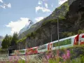 The Glacier Express train winds through the Swiss Alps, with the Matterhorn in the distance. Is the Glacier Express worth it? This view suggests yes!