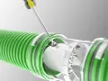 A screwdriver adjusts a clear dial on a green hose, indicating the regulador caudal.