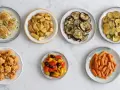 Sette piatti di verdure in friggitrice ad aria: finocchi, patate, melanzane, zucchine, cavolfiore, peperoni e carote.