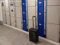 Przechowalnia bagażu Warszawa Centralna. Czarna walizka czeka przed rzędem szafek.