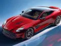 Czerwony Aston Martin Vanquish z brązowym wnętrzem i czarnym dachem, prezentujący swoje sportowe linie na tle błękitnego nieba.