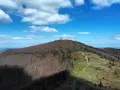 Widok na górzystą polanę w Polsce, z wieżą widokową na szczycie.