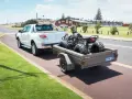 Un quad è trasportato su un rimorchio, parte integrante del veicolo, pronto per l'avventura.