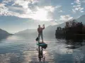 Person auf einem Stand Up Paddle Board, genießt die Aussicht und verbrennt dabei effektiv Stand Up Paddle Kalorien.