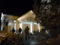 Abendliche Beleuchtung am **Schlosspark Theater**. Drei Personen nähern sich dem Eingang.