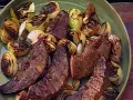 Sabroso hígado encebollado a la parrilla, con trozos de cebolla caramelizada y tiernas lonchas de hígado.