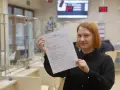 Kobieta trzyma w ręku wniosek o przyznanie dodatku mieszkaniowego.