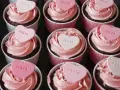 Rosa cupcakes med hjärtformade dekorationer med texten "JULIA". Perfekt för en speciell Julia!