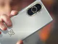 Dłoń trzyma srebrny Huawei Nova 10 Pro, ukazując moduł potrójnego aparatu z 50MP RYYB sensorem.